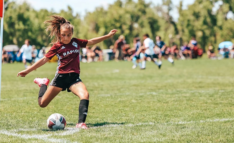 A youth female soccer player taking a corner kick during a Storm tournament in Colorado 2