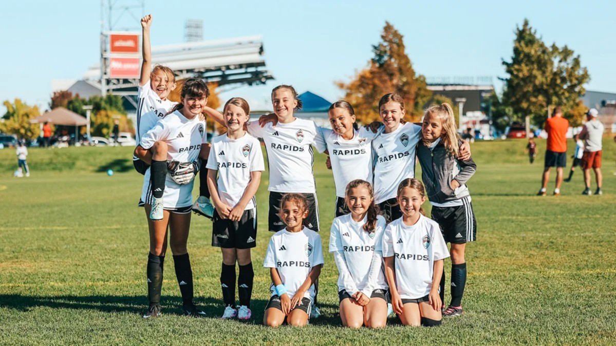 A youth girls recreational soccer team poses together after a game at a Denver Storm tournament