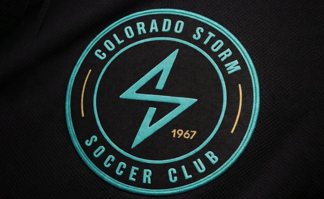 Close up of an embroidered Colorado Storm Soccer Club patch on a black jersey