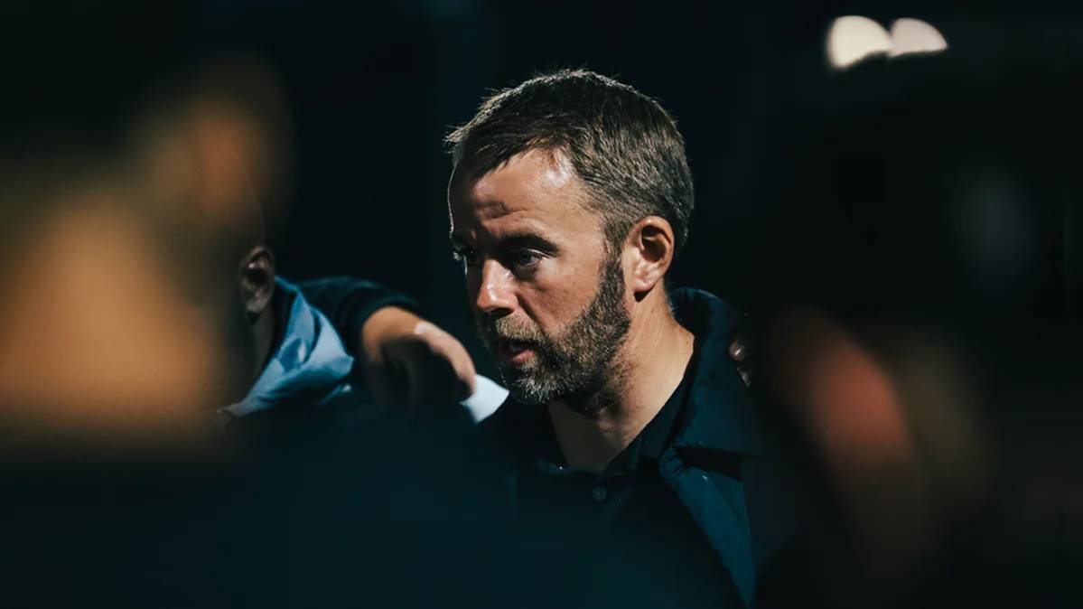Colorado Storm soccer coach talking to players in a huddle during a night match in Denver 1