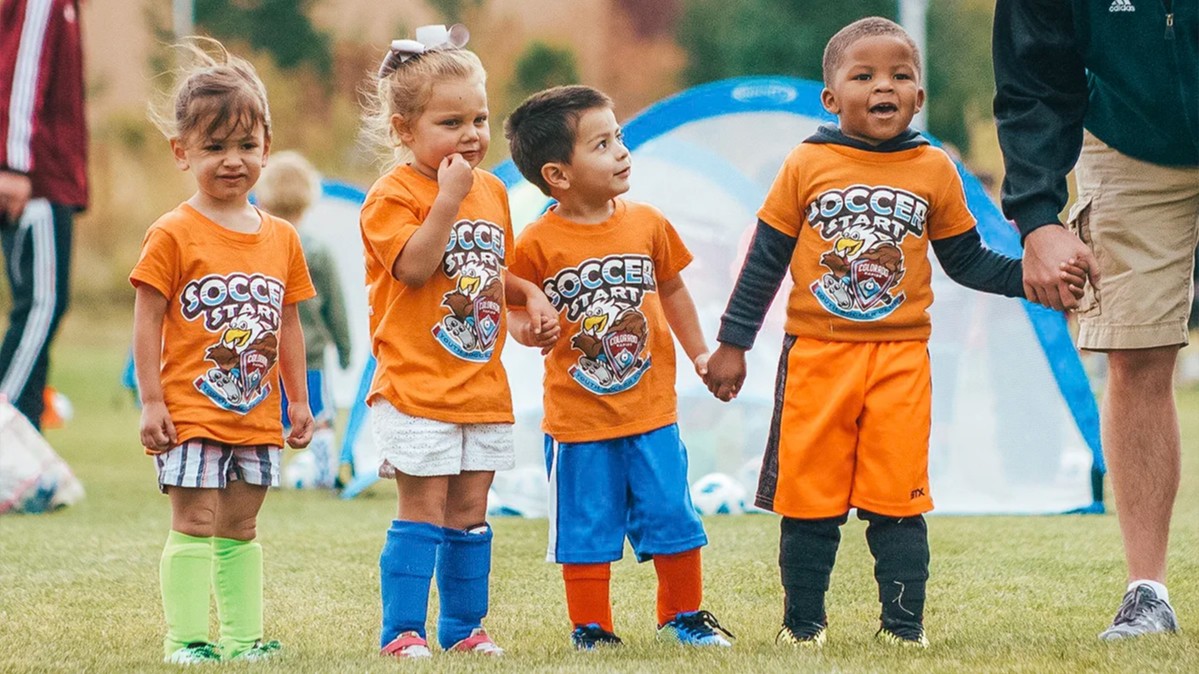 Four young Sparks soccer players holding hands