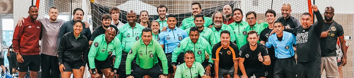 Large group of futsal referees posing together on an indoor court in Colorado 1