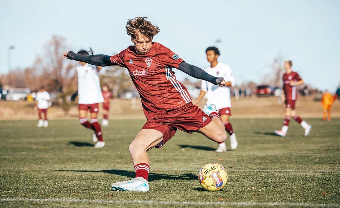 National platform soccer player striking a ball during a soccer match in Colorado