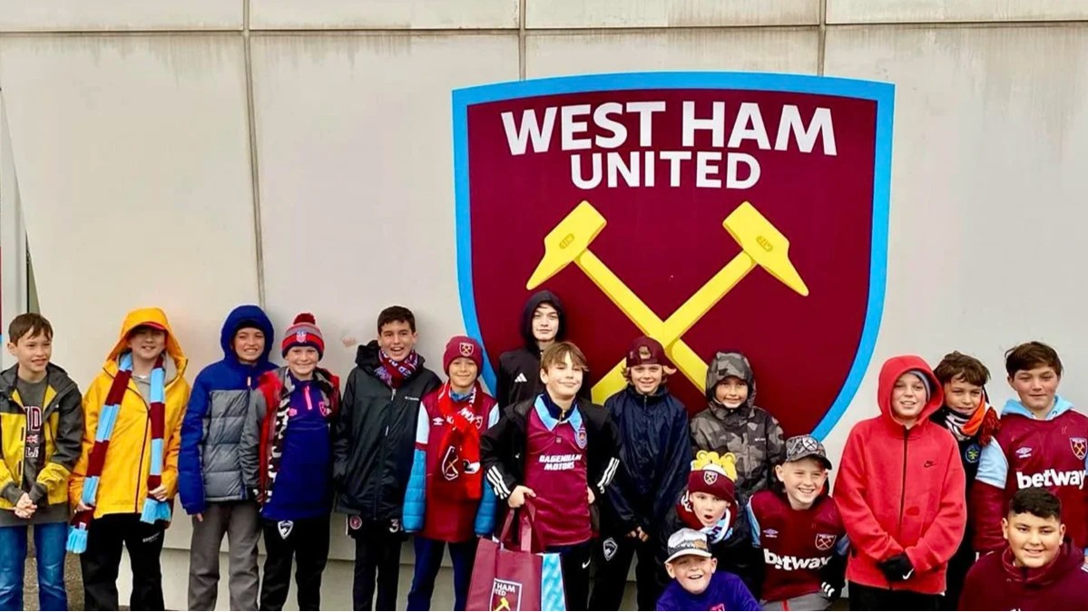 Storm recreational soccer players pose in front of the West Ham United logo during an international trip