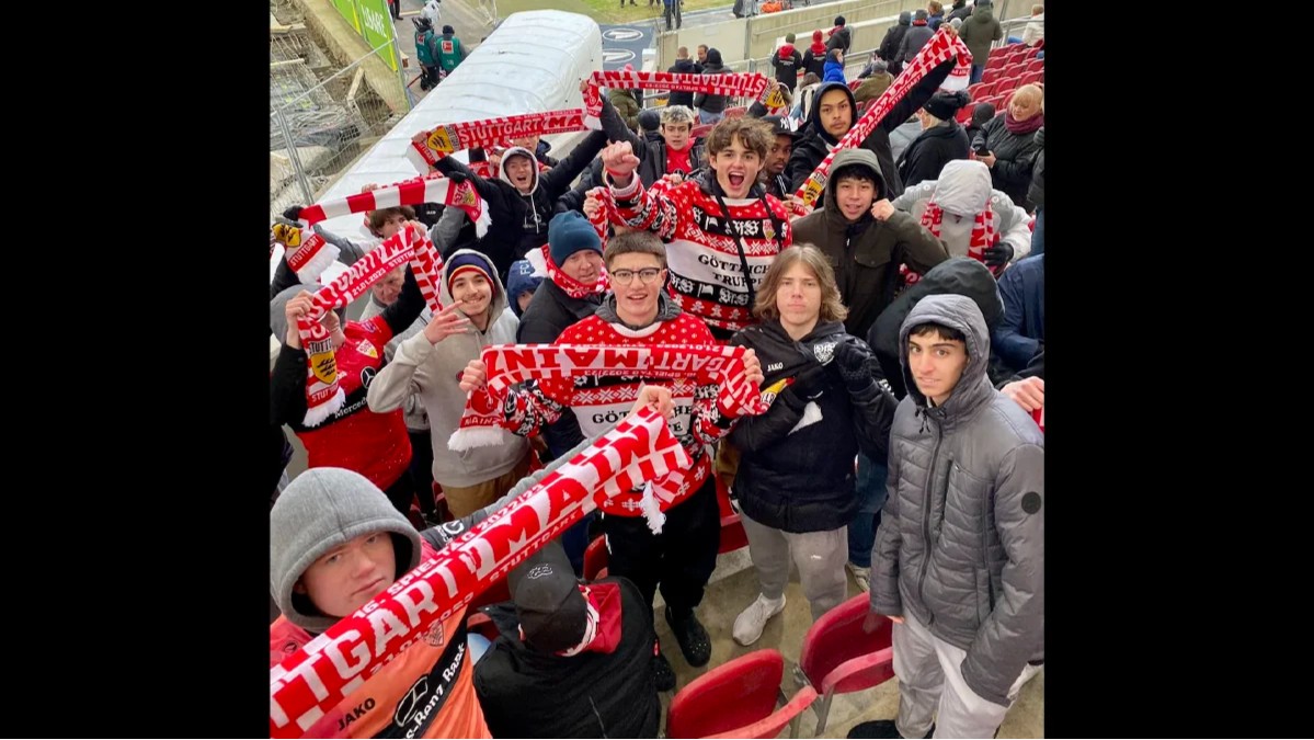 Storm soccer players hold scarves and cheer during a Mainz match on an international trip to Germany