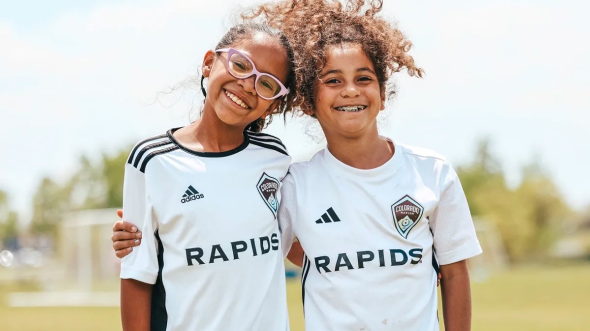 Two young girls in Rapids jerseys hugging