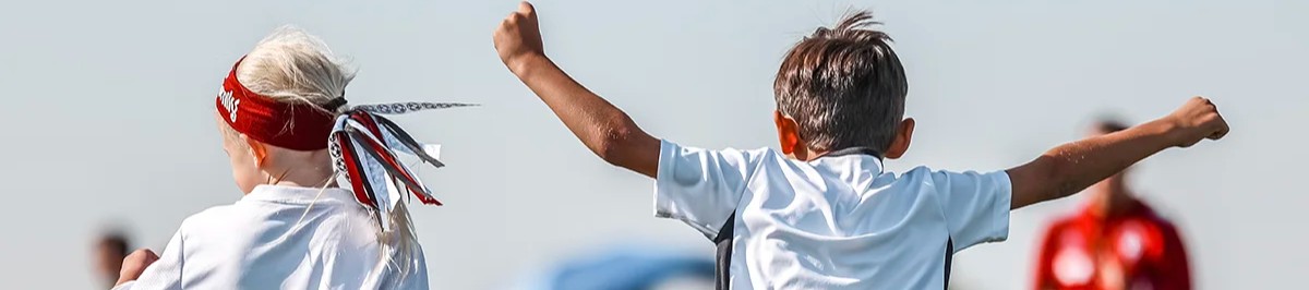 Two young recreational soccer players celebrate a goal with arms raised at a Colorado Storm tournament 3