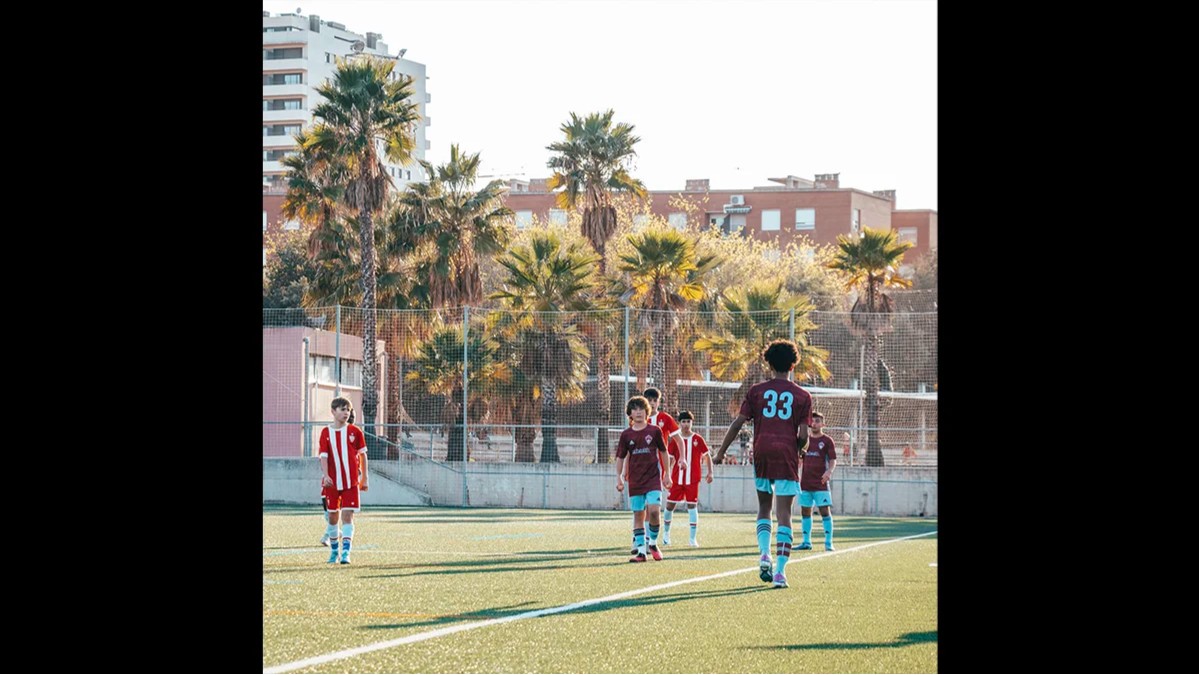 Young Storm soccer players compete in an international match on a sunny field in Spain