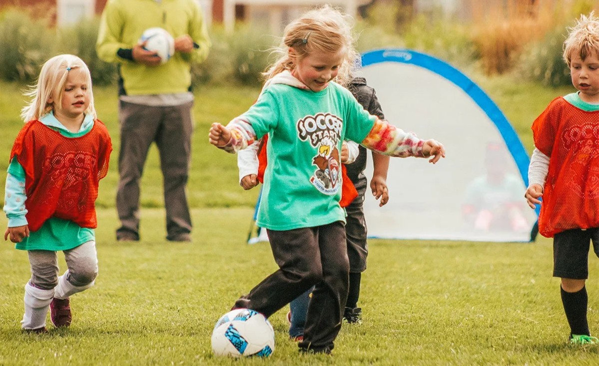 Young girl dribbling a soccer ball during a Sparks practice in Colorado