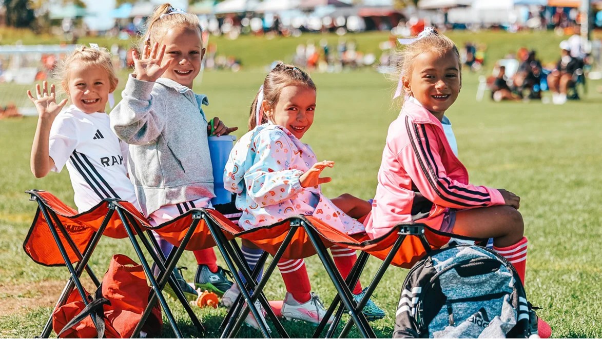 Young soccer players waving at soccer tournament