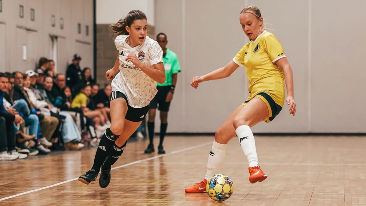 Youth futsal player dribbling past an opponent