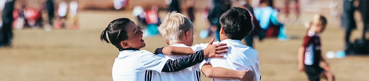Youth soccer players celebrating together after scoring a goal at a Colorado tournament 2