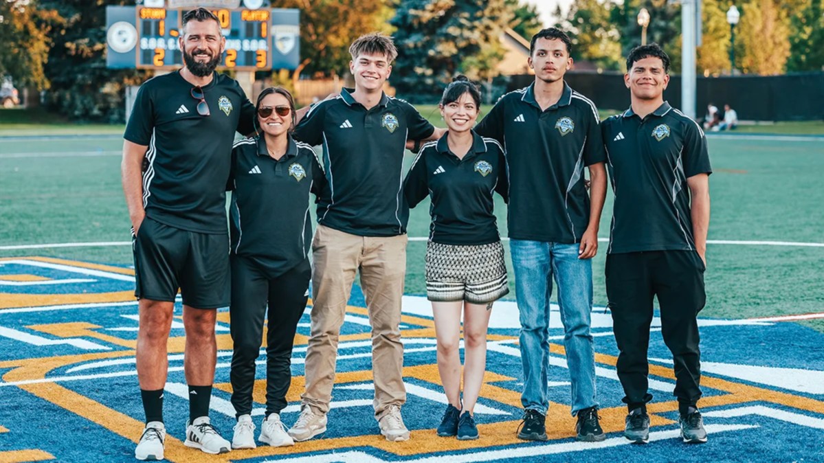 group of soccer volunteers smiling at a stadium
