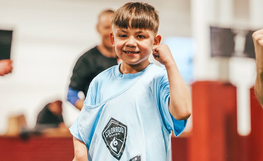 young adaptive soccer player flexing and smiling