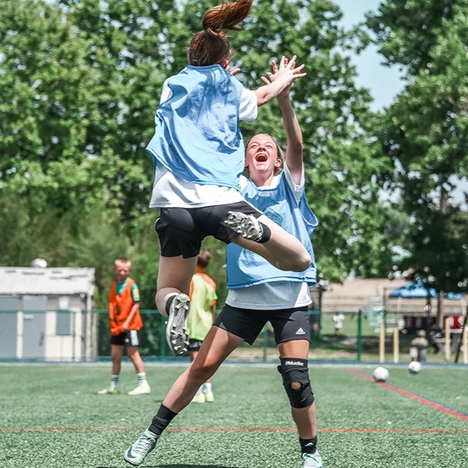 youth soccer players jumping for a high five celebration during a game in denver colorado